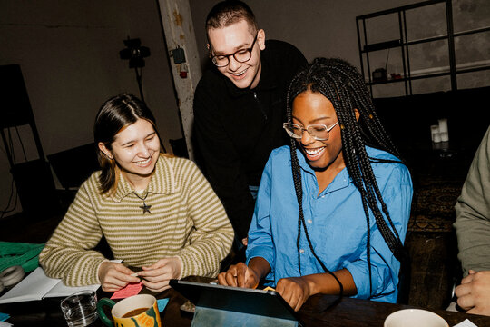 Happy multiracial male and female business professionals working together at tech-start up office