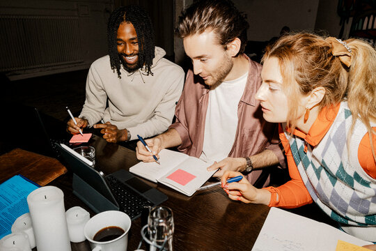 Male and female business professionals discussing over tablet PC while working at office