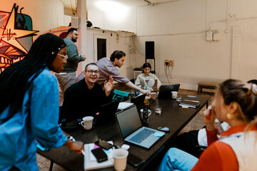 Group of male and female business professionals working together at tech-start up office