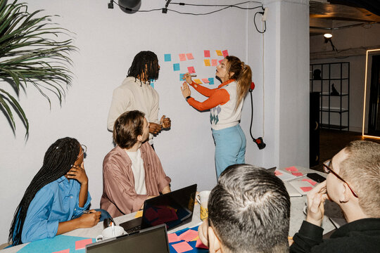 Female entrepreneur doing brainstorming session with colleagues in meeting at office