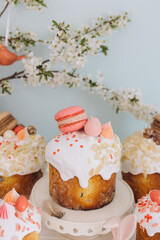 Delicious easter cakes decorated with macarons and meringue under a flowering branch