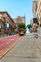 Fototapeta na wymiar A view of a cable car coming down Powell Street from Union Square in the morning in San Francisco in early springtime