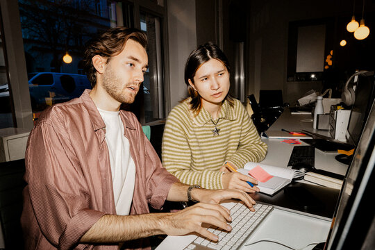 Male and female entrepreneurs working together on computer at office