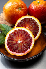 Sicilian sweet juicy yellow and red blood oranges with green leaves close-up