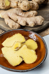 Fresh organic ginger rhizome root used in traditional medicines and for flavoring meals, drinks, sliced in pieces