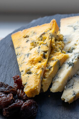 Cheese plate, English cow milk semi-soft, crumbly old blue stilton and blue shropshire cheeses sliced
