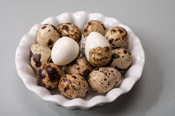 Fresh small spotted partridge or quail bird eggs uncooked and cooked
