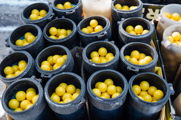 A captivating collection of sleek black containers filled with vibrant yellow balls, creating an alluring sight that consistently attracts onlookers and intrigued passersby