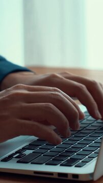 Businessman hand work on capable laptop computer at office table close up shot and selective focus at middle section of laptop computer keyboard while typing and working