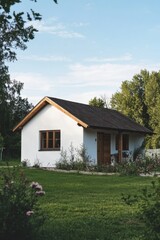 Nestled in a picturesque rural setting, this delightful small white house features elegant wooden accents and a lovely garden, all embraced by lush trees on a bright, sunny day