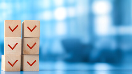 Wooden blocks with check marks stacked on blue background, symbolizing organization and achievement. This conveys sense of accomplishment and clarity in tasks