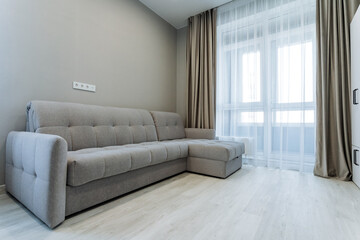This living room features a comfortable couch, elegant curtains, and a large window that lets in...