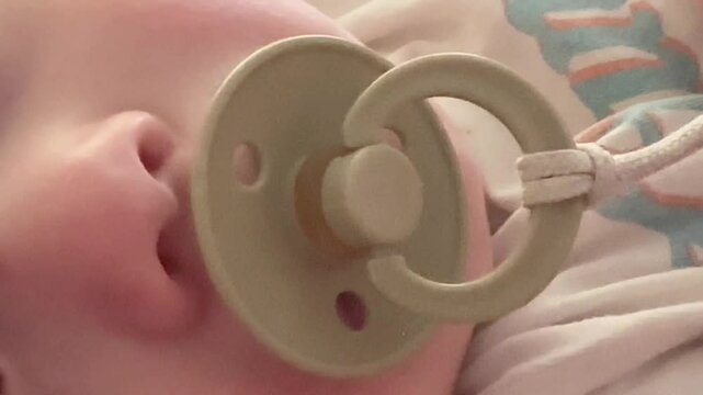 Baby sucks pacifier close-up video