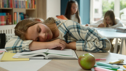 Tired exhausted kid schoolgirl teen Caucasian child daughter girl pupil school student sleeping desk books boring homework nap lack energy overwork education learning studying classroom sleep on table