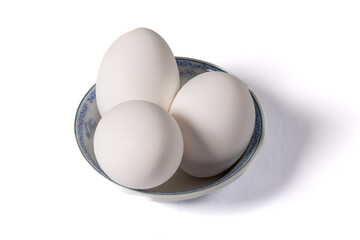 Three white eggs in a small dish isolated on white © SockaGPhoto
