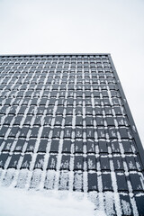 The roof of a tall building is covered in a thick layer of fluffy, sparkling snow, creating a stunning winter scene that showcases the enchanting allure of the cold season