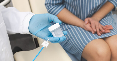 Gynecologist doctor taking smear for cytology from female patient in gynecological office, close-up. PAP test, cervical screening test