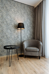 The living room features a cozy armchair, modern coffee table, and stylish lamp, creating a warm atmosphere perfect for relaxation or socializing with family and friends