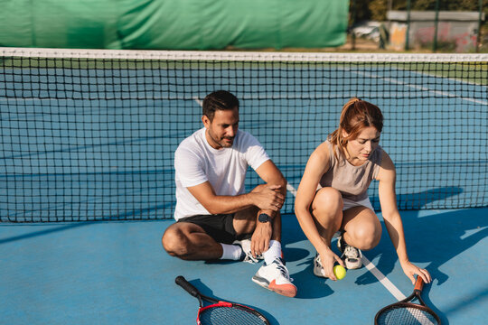Young couple playing tennis outdoors enjoying a fun summer game