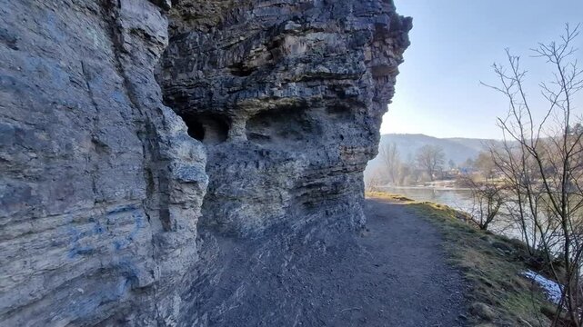 The limestone cliff with its layered structure forms cavities and overhangs above the river. The beautiful carved paths were created by the inhabitants of this valley in the past.