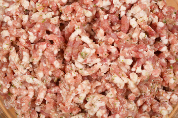 A close-up shot of seasoned ground pork with garlic, parsley, and spices, ready for sausage making,...