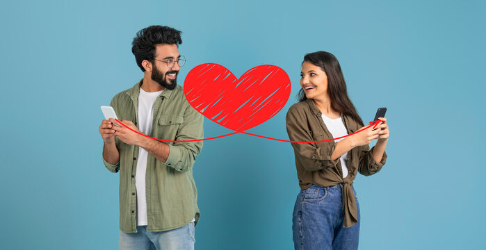 In a joyful celebration of St. Valentine's Day, a couple stands together, smiling and sharing affectionate moments while using their smartphones. They connect through messages, symbolizing love.