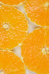 A close-up, top-down shot of several orange slices arranged in a pattern, highlighting their...