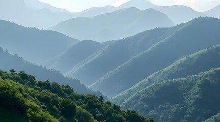 Obraz premium Layered mountain landscape shrouded in mist, featuring lush green hills and a tranquil atmosphere ideal for outdoor exploration and relaxation. 