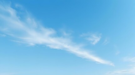 Obraz premium A tranquil blue sky adorned with soft, fluffy clouds, creating a serene atmosphere perfect for relaxation and inspiration in nature. 