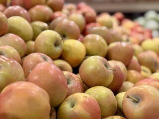 Box filled with fresh natural bio organic red yellow coloured apples placed on counter in local food market. Close-up