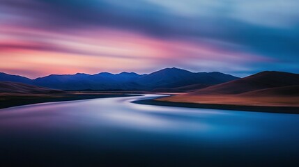 Fototapeta premium A river flows through a verdant valley beneath a vibrant purple and blue sky, framed by majestic mountains