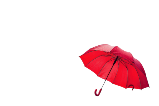 A striking red umbrella rests on a warm surface under soft natural light in a serene setting isolated on transparent background