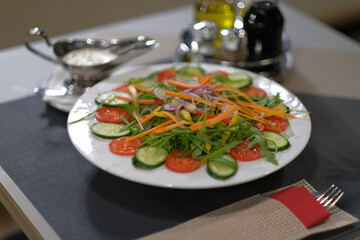 Delicious and fresh garden salad with various vegetables served on a white plate with a side of creamy dressing A healthy and colorful meal