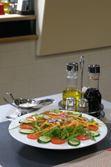 Fresh salad with vibrant vegetables and dressings a healthy and appetizing meal option served on a white plate with condiments