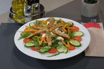 Chicken Salad Delight: Fresh arugula cucumbers tomatoes peppers and carrots topped with grilled chicken and a creamy dressing