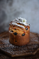 Easter cruffin with raisins and icing sugar on a wooden board.