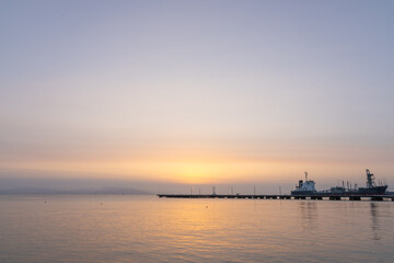 Sunsets over bay delivering a golden glow over calm water