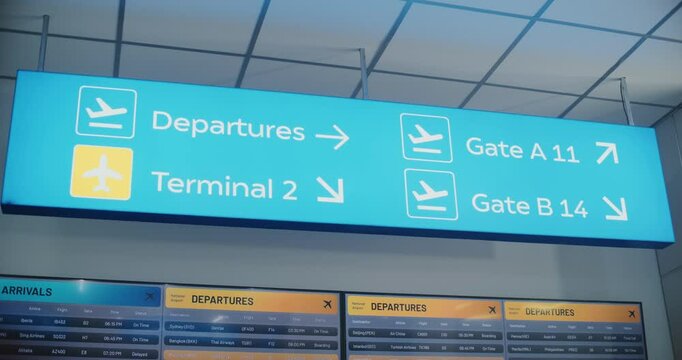 Modern Bright International Airport Terminal: Illuminated LED Sign Directing Passengers to Departures, Terminals, Gates for Boarding Flight, Hanging on Ceiling. Digital Arrival and Departure Display.