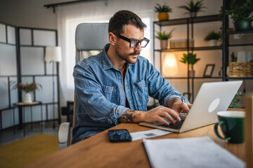 Obraz premium focused concentrated man work on laptop from home office