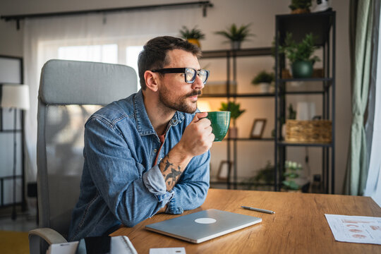 relaxed man with eyeglasses drink first coffee from home office