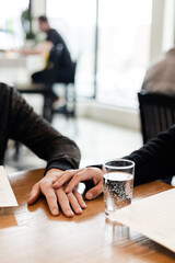 A vertical close up of a gay men couple on a date in a cozy cafe
A close up of a LGBTQ+ couple on a romantic date, sitting by a table and holding hands, stroking them