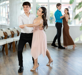 Fototapeta premium Young man and young woman dance couple latin dances in studio