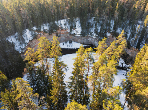 Aerial drone view of the snowy Taevaskoda nature trail, highlighting Suur Taevaskoda sandstone cliffs in Estonia.