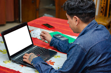 Man home shopping with a credit card and paying taxes with credit card with a laptop computer