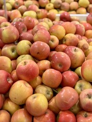 Box filled with fresh natural bio organic red yellow coloured apples placed on counter in local food market. Close-up