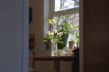 Fototapeta premium White roses in a vase on a wooden table