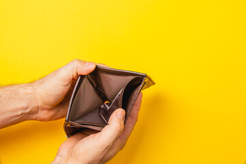 Male businessman opens empty wallet representing financial crisis and despair