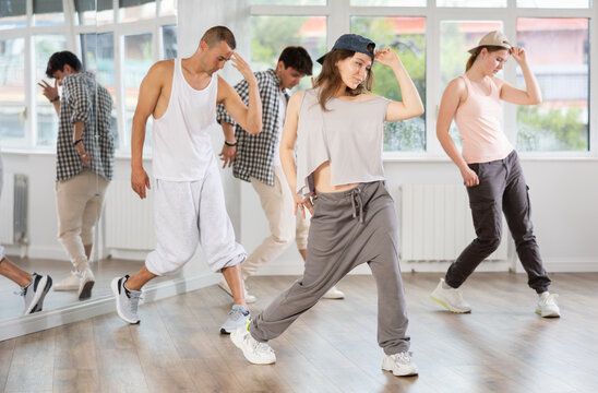 Group of young people perform choreographic exercises and teaches energetic mobile social dance waacking