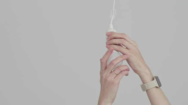Woman uninstalling an LED light bulb from a ceiling socket, home maintenance and electrical repair