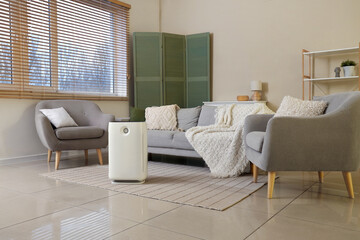 Interior of living room with air purifier, sofa and armchairs